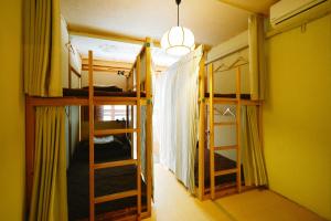 a room with two bunk beds and a room with a hallway at Hostel&Bar CAMOSIBA in Yokote