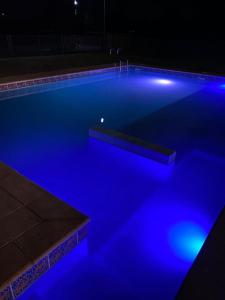 una piscina con luces azules en la oscuridad en Cabaña Cumbre Algarrobo, en Algarrobo