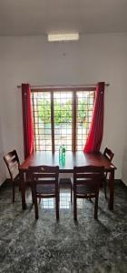 a wooden table and chairs in a room with a window at The Grand White House - Entire Villa in Thekkady +33 photos
