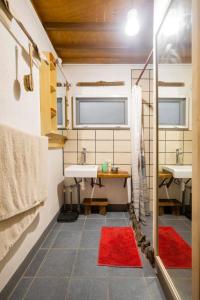 a bathroom with two sinks and a red rug at Private Nature Retreat w/Brick Oven & Hiking in Lipa