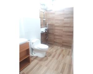 a bathroom with a white toilet and a shower at Aipayung Homestay 