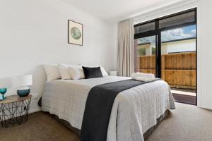 1 dormitorio con cama y ventana grande en Custom designed holiday home, next to Cycleway., en Te Aroha