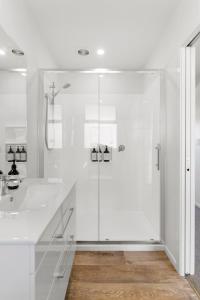baño blanco con ducha y lavamanos en Custom designed holiday home, next to Cycleway., en Te Aroha