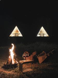 een kampvuur met een tafel en een vuurplaats bij Roots Svaneti ' რუთს სვანეთი in Lentekhi