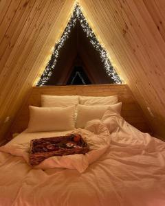 duże łóżko w pokoju z choinką świąteczną w obiekcie Roots Svaneti ' რუთს სვანეთი w mieście Lentekhi