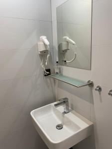 a white bathroom with a sink and a mirror at Penzion Na Hradbách in Slavkov u Brna