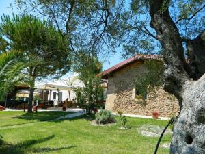 uma casa com uma árvore num quintal em Agriturismo Masseria Baronali em Borgagne