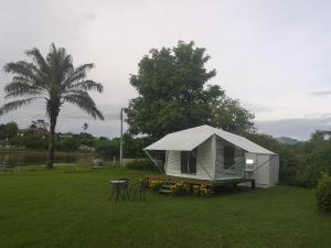 a tent in a yard with a table and chairs at Buasawan Resort & Restaurant in Kanchanaburi City