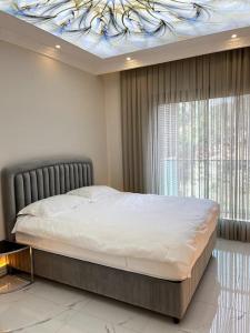 1 dormitorio con 1 cama y ventana con techo en Premium Mediterranean Apartment, en Alanya