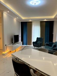Habitación con sillas, mesa y TV. en Premium Mediterranean Apartment, en Alanya