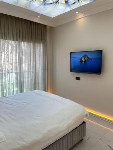 1 dormitorio con 1 cama y TV de pantalla plana en Premium Mediterranean Apartment, en Alanya