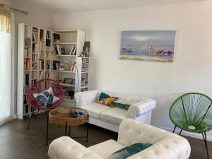 ein Wohnzimmer mit einem Sofa und 2 Stühlen in der Unterkunft Villa Rose Suite et chambres in Montpellier