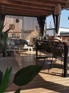 a patio with chairs and a couch and tables at Hollers Holiday Homes Haus Mary in Drage