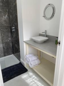 a white bathroom with a sink and a shower at Cornish Billys Barn in Penzance +24 photos