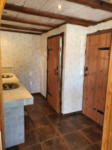 a kitchen with wooden doors and a tile floor at Svensson's Log Cabins in Osby