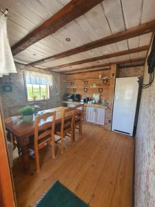 a dining room with a wooden table and a kitchen at Svensson's Log Cabins in Osby