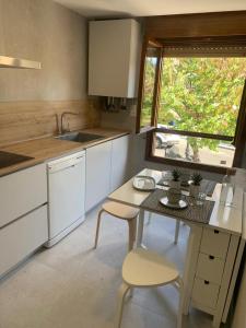 托萊多的住宿－Vega del Tajo- CON PARKING GRATIS，厨房配有桌子、椅子和窗户
