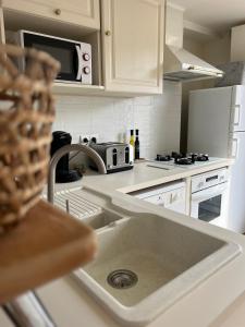 a kitchen with a sink and a microwave at Duplex bord de mer La Madrague in Marseille