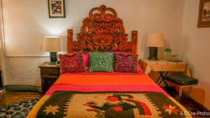 a bedroom with a large bed with a large wooden headboard at Casona Rosa B&B, Morelia in Morelia