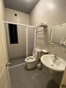 a white bathroom with a toilet and a sink at 晨光夜色 in Magong