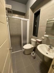 a bathroom with a shower and a toilet and a sink at 晨光夜色 in Magong