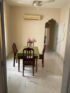 a dining room table with a green table cloth and chairs at old muscat in Muscat