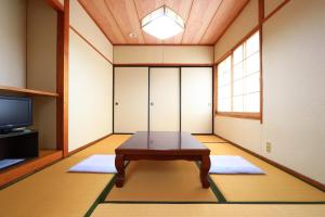 una stanza con tavolo al centro di una stanza di Suikoen a Yonago