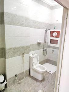 a small bathroom with a toilet and a shower at رحاب السعاده rehab alsaadah apartment in Salalah