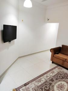 ein Wohnzimmer mit einem Sofa und einem Flachbild-TV in der Unterkunft رحاب السعاده rehab alsaadah apartment in Salalah