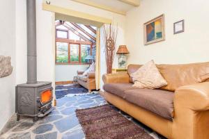 a living room with a couch and a wood stove at Cat's Cradle, Cottage In Beautiful and Peaceful Location, Near Beach in Sennen