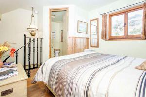 a bedroom with a large bed and a window at Cat's Cradle, Cottage In Beautiful and Peaceful Location, Near Beach in Sennen