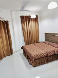 1 dormitorio con 1 cama en una habitación con cortinas en رحاب السعاده rehab alsaadah apartment, en Salalah