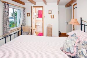 a bedroom with two beds and a bathroom at Sheldrake, Spacious Villa, Panoramic Sea-views, Large Garden, By Beach in Sennen