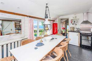 a kitchen with a table and chairs in a room at Sheldrake, Spacious Villa, Panoramic Sea-views, Large Garden, By Beach in Sennen