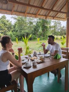 The View Hotel Sigiriya في سيجيريا: مجموعة من الناس يجلسون على طاولة يأكلون الطعام