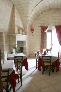 a dining room with two tables and a fireplace at Agriturismo Masseria Baronali in Borgagne