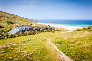 a house on a hill next to the beach at Basking Shark, Studio Cottage With Superb Sea Views By Beach in Sennen