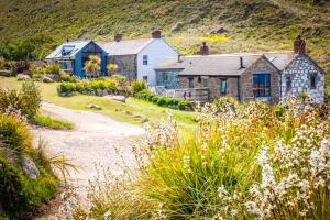 セネンにあるGirl Annie, Cornish Cottage With Superb Sea Views & Garden, By Beachの花の庭のある丘の上の家
