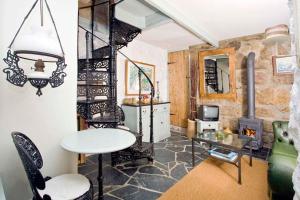 uma sala de estar com uma mesa e uma lareira em Little Petra, Cottage With Garden, Superb SeaViews in Amazing Location em Sennen
