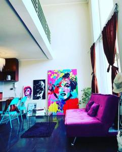 una sala de estar con un sofá rosa y una pintura en APART SANTIAGO, en Santiago