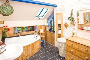 baño con bañera grande y lavamanos en Penrose, Cornish Cottage With Sea Views, Garden & Patio By the Beach, en Sennen