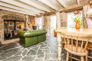 sala de estar con mesa y chimenea en Penrose, Cornish Cottage With Sea Views, Garden & Patio By the Beach, en Sennen