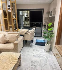 Modern apartment kantaoui sousse في Dar el Saïd: غرفة معيشة مع أريكة وطاولة