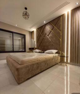 Modern apartment kantaoui sousse في Dar el Saïd: غرفة نوم بسرير كبير وبجدار كبير