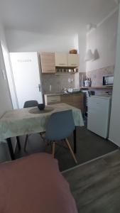 a kitchen with a table and chairs and a refrigerator at Scala Soba in Bačka Topola