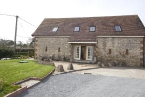 una casa de piedra con una entrada delante de ella en The Old Barn, Newclose Farm, en Yarmouth