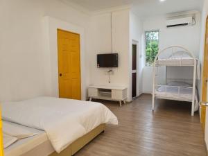ein Schlafzimmer mit einem Bett und einem Etagenbett in der Unterkunft TERATAK AL QARNI in Jitra