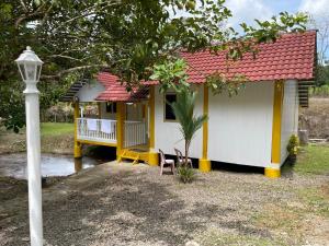 a small yellow and white house with a red roof at TERATAK AL QARNI in Jitra