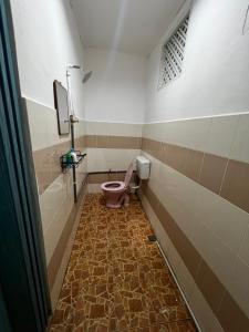 a bathroom with a pink toilet in a room at TERATAK AL QARNI in Jitra