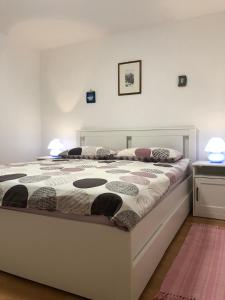 Apartman Legac في ستاريغراد: سرير في غرفة نوم عليها مصباحين